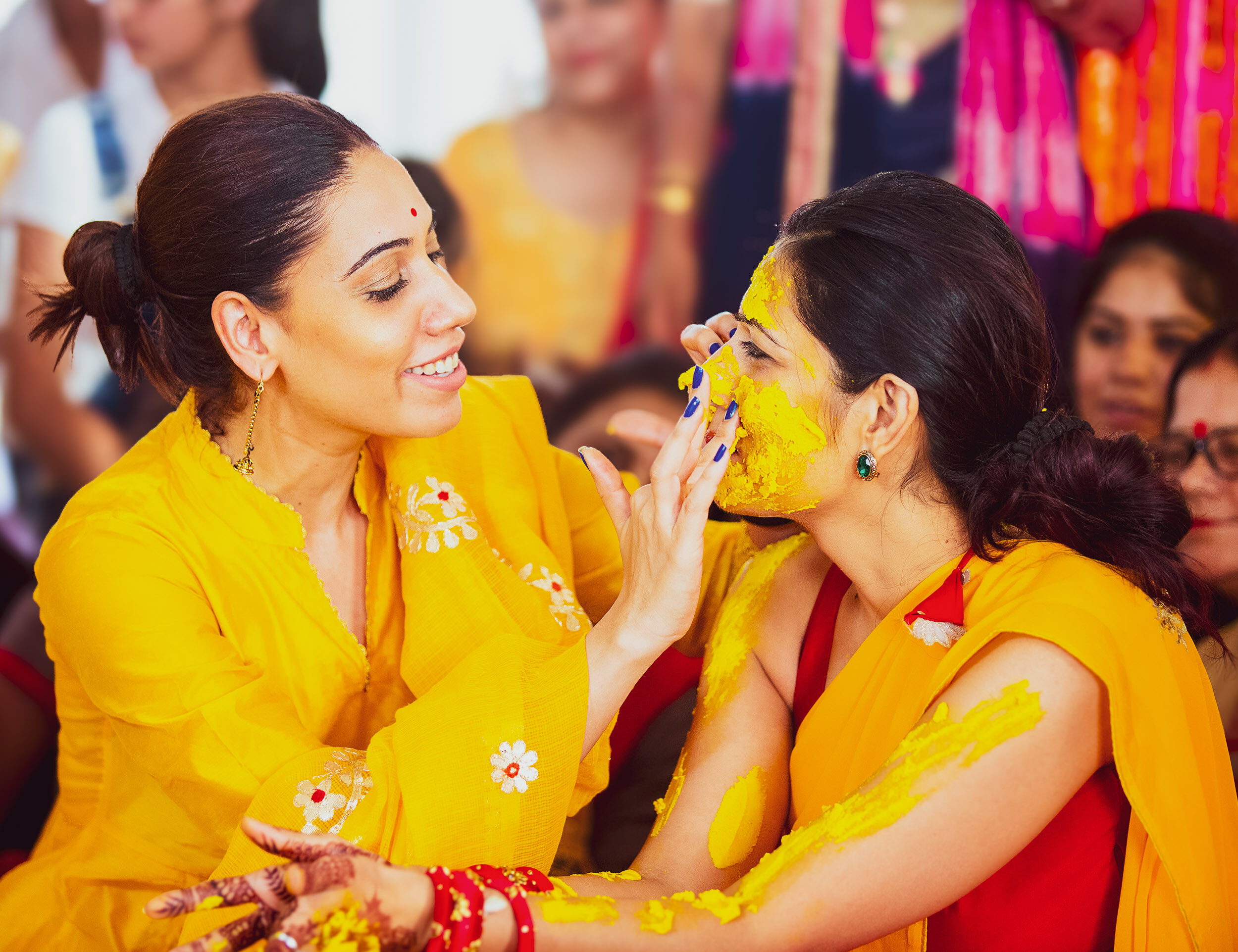 Women applying haldi on brides face on her haldi ceremony